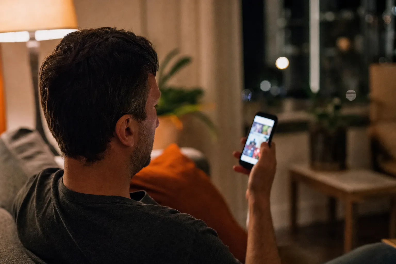 A homeowner scrolling a social media feed on a phone in the evening